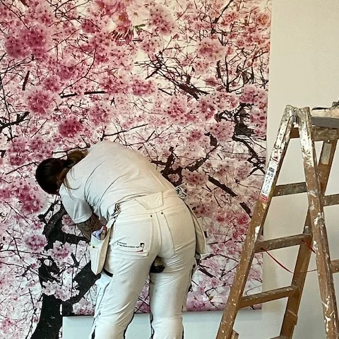 Maler arbejder med vægudsmykning på plejehjemmet Rosenlunden